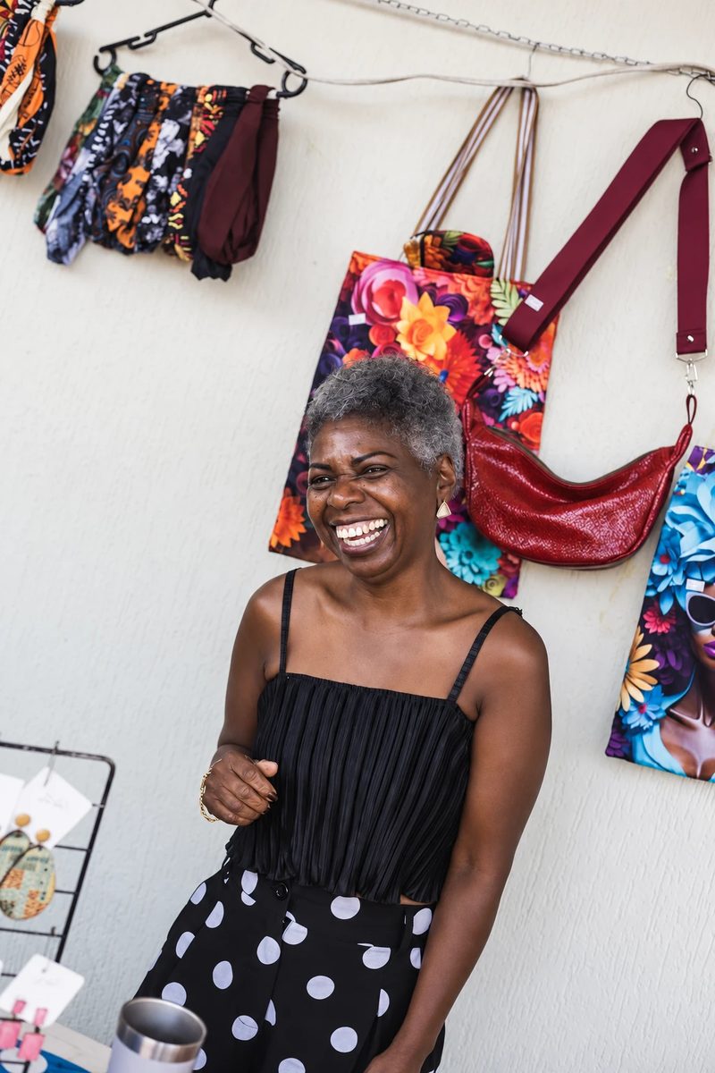 A shop owner in front of her handbags